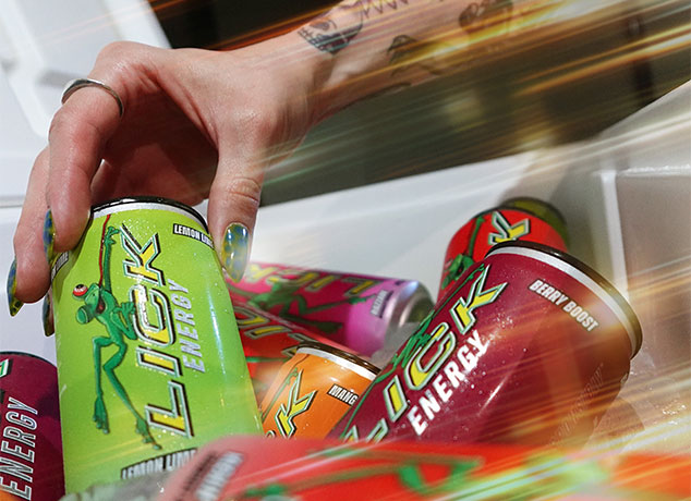 Hand reaching for a Lick Energy drink can among other Lick Energy flavors.