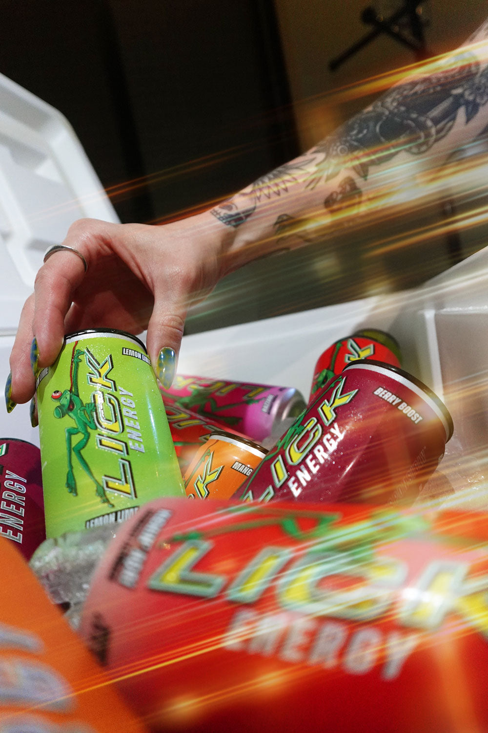 Hand reaching into a cooler filled with energy drinks, including Lick Energy.