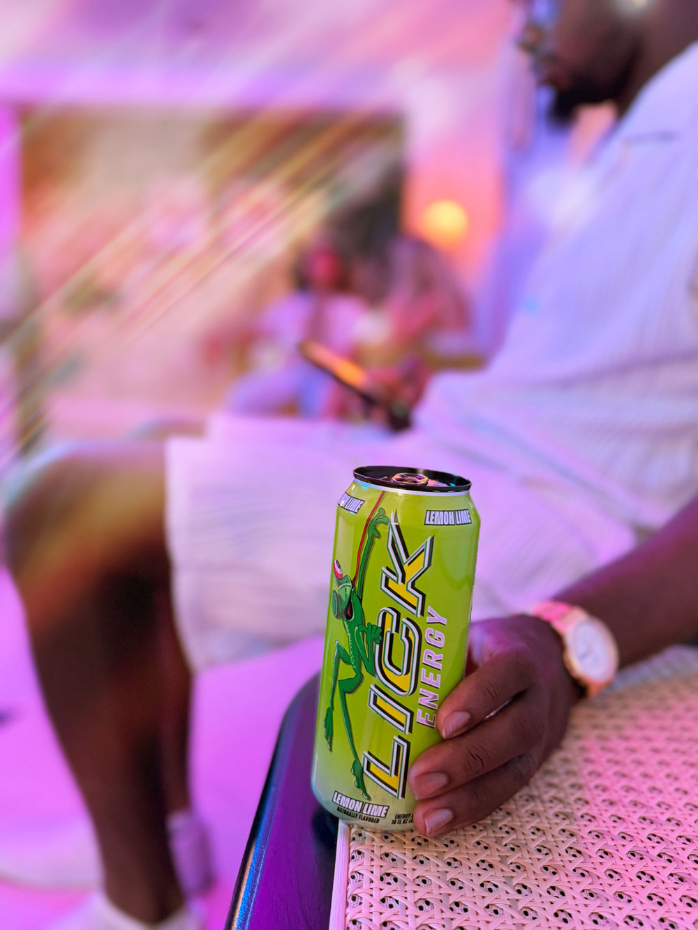Person holding a can of Lick Energy drink with a blurred background
