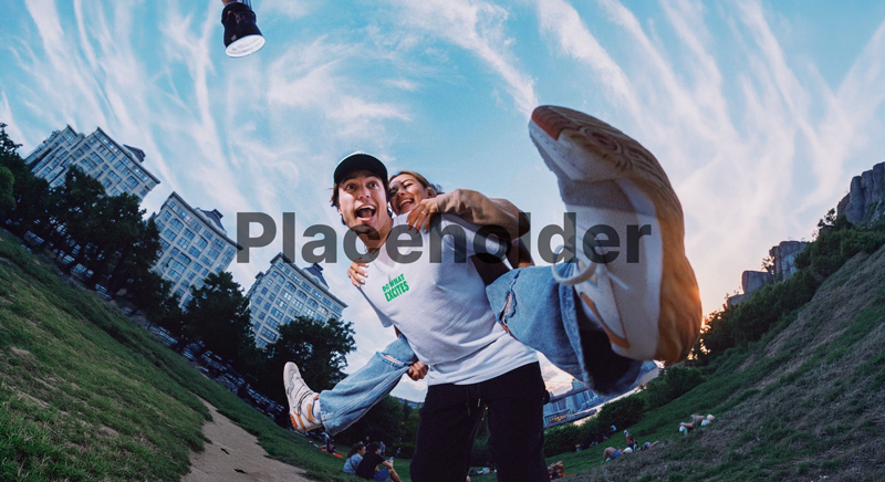 Two people in a park with a cityscape background